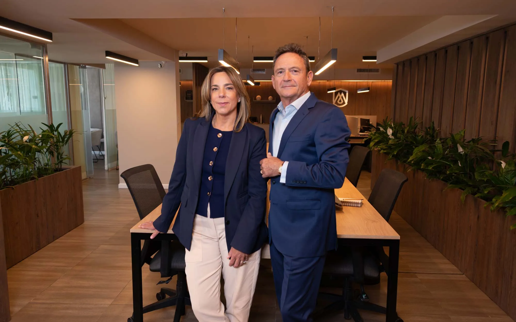 Dos integrantes del estudio de pie en el área de trabajo